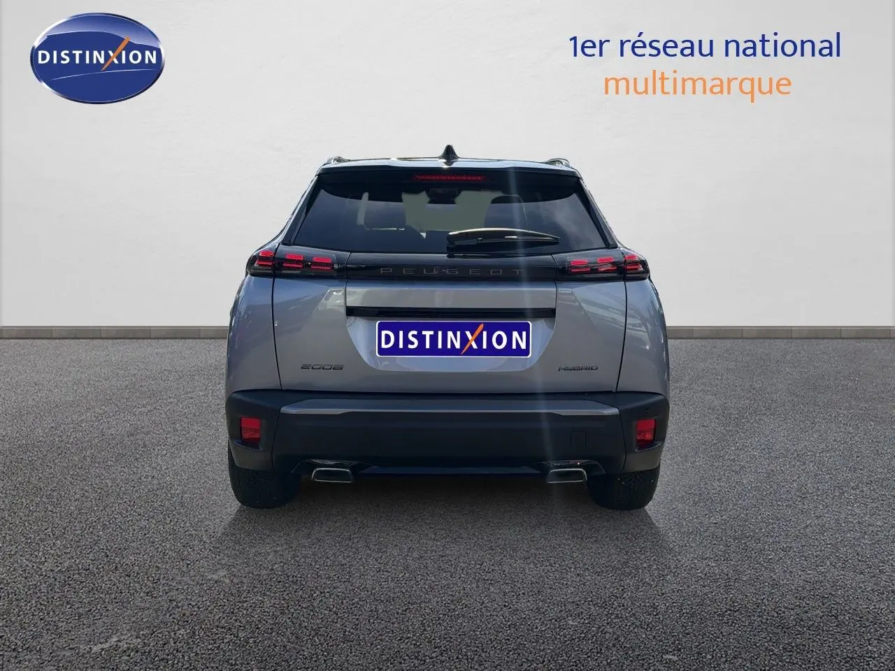 Vue arrière d'un Peugeot 2008 gris Artense avec toit noir, mettant en valeur ses feux LED et double sortie d'échappement.