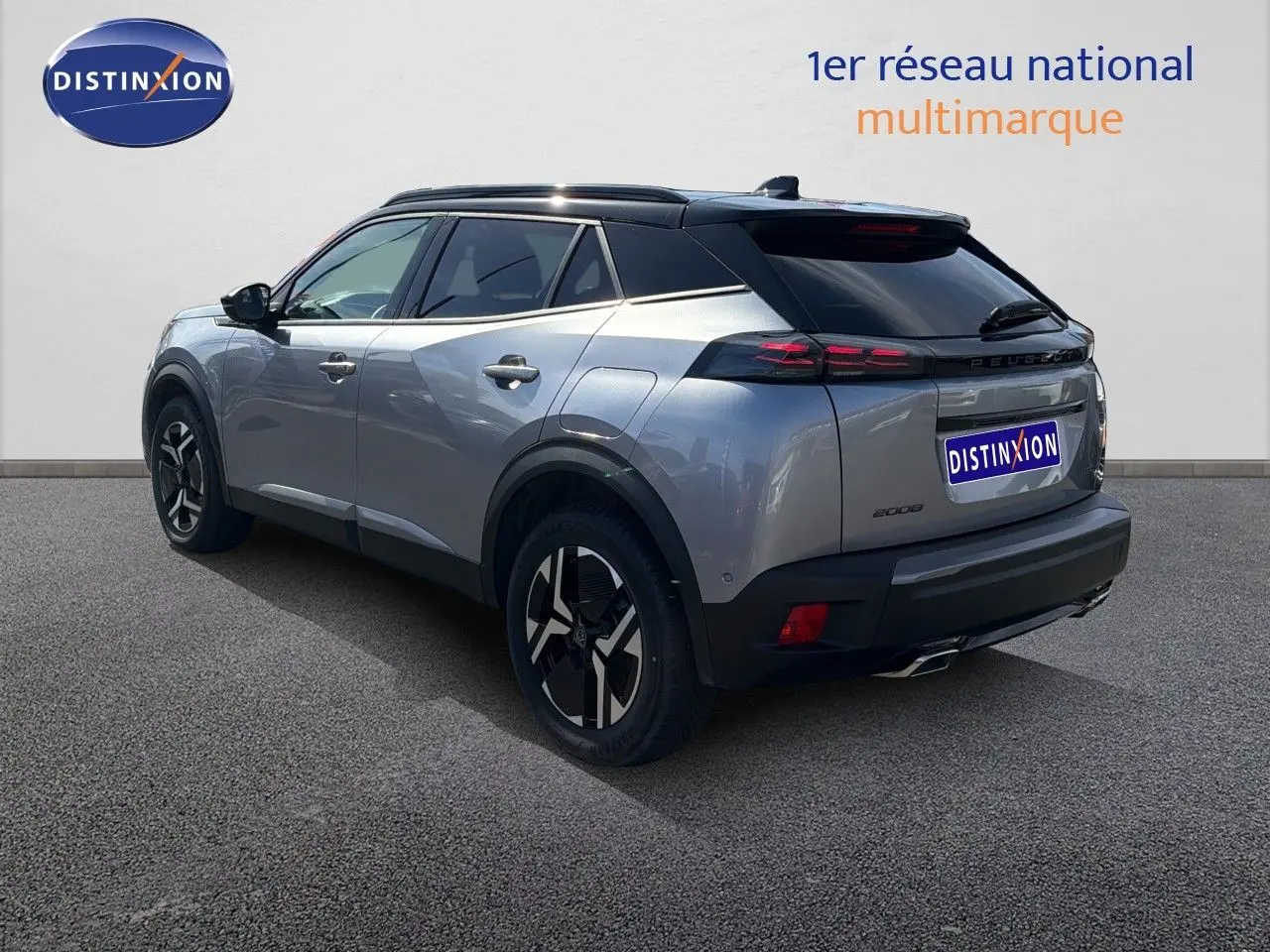 Peugeot 2008 1.2 Hybrid 145 GT gris Artense avec toit noir, vue 3/4 arrière côté gauche, jantes noires distinctives.