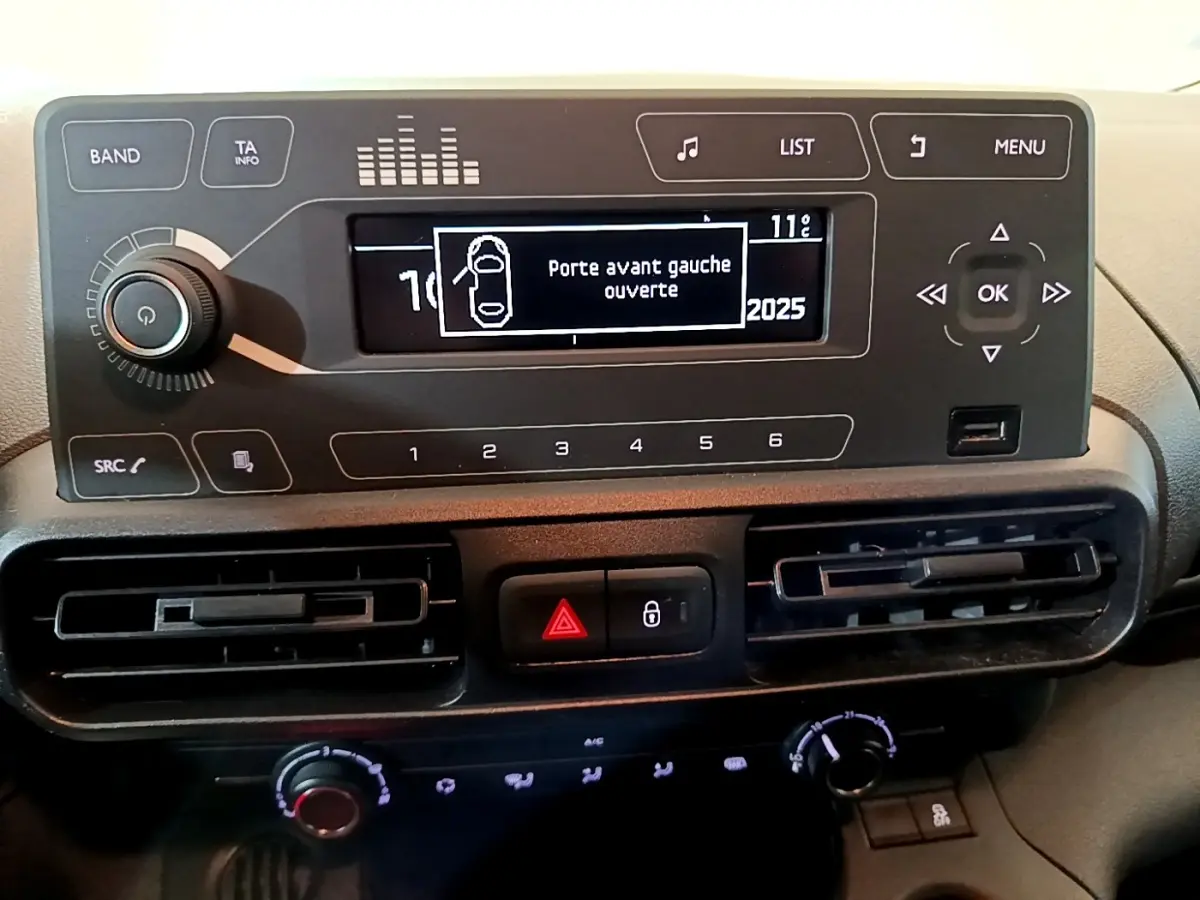 Tableau de bord noir du Citroën Berlingo 2021 avec écran central indiquant porte avant gauche ouverte.
