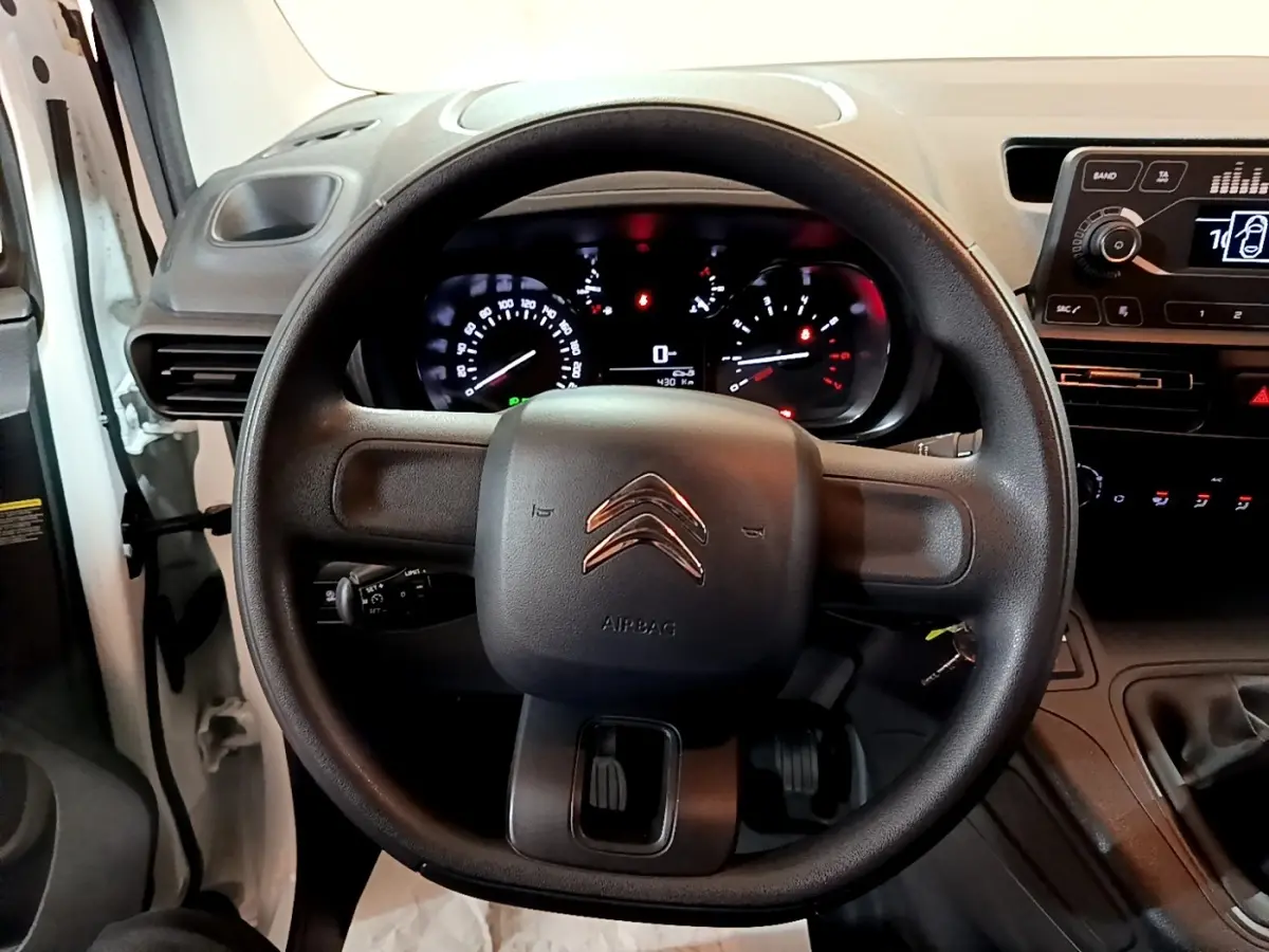 Vue rapprochée du volant noir de la Citroën Berlingo 2021 avec tableau de bord et commandes visibles.