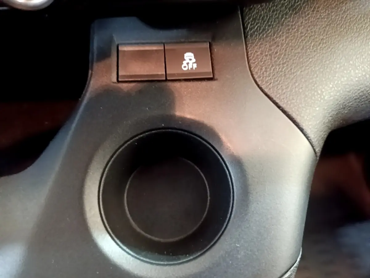 Gros plan sur le bouton de contrôle de l'antipatinage noir dans l'habitacle du Citroën Berlingo blanc.