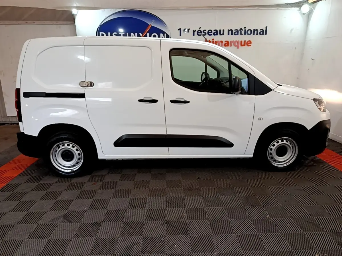 Profil droit d'un utilitaire Citroën Berlingo blanc 2021 avec portes latérales pleines et jantes acier simples.