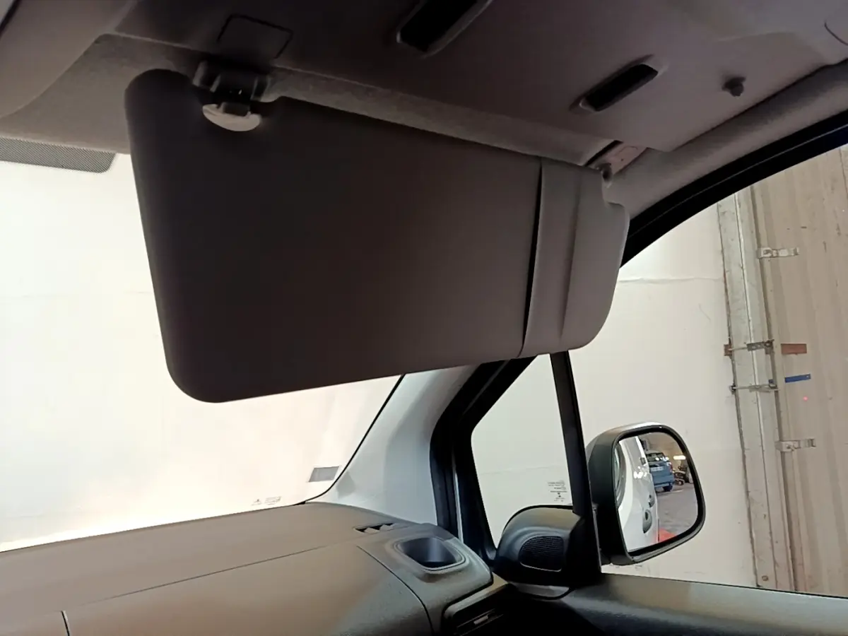 Intérieur du Citroën Berlingo 2021, vue côté passager avec pare-soleil baissé et rétroviseur extérieur visible.