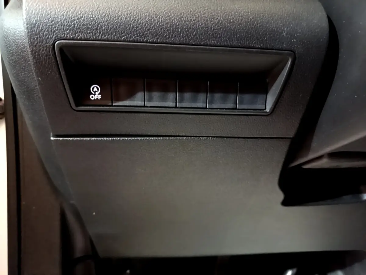 Gros plan sur le tableau de bord noir du Citroën Berlingo 2021 montrant le bouton arrêt du système start-stop.