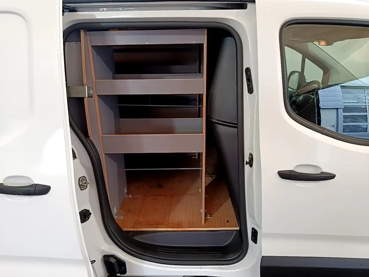 Vue latérale gauche du Citroën Berlingo blanc 2021 avec porte coulissante ouverte montrant les étagères de rangement intérieures.