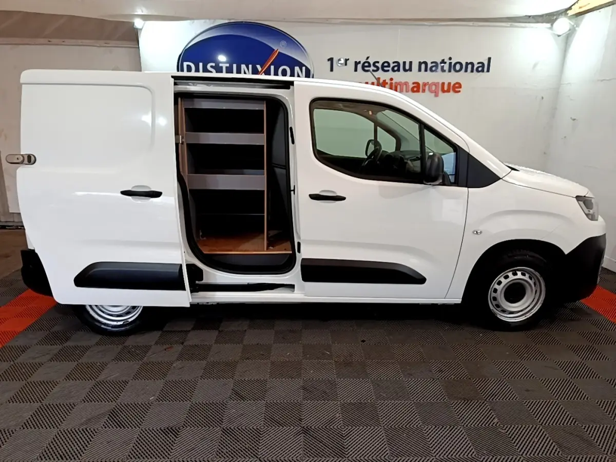 Vue latérale droite d'un Citroën Berlingo blanc 2021 avec porte coulissante ouverte révélant l'intérieur aménagé en étagères.