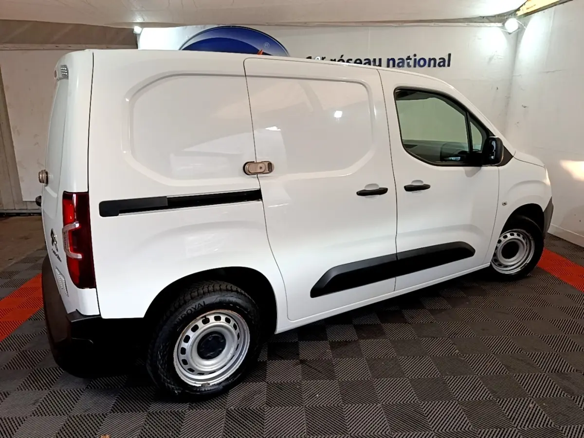 Vue latérale droite d'un utilitaire Citroën Berlingo blanc avec cloison pleine et jantes acier en intérieur.