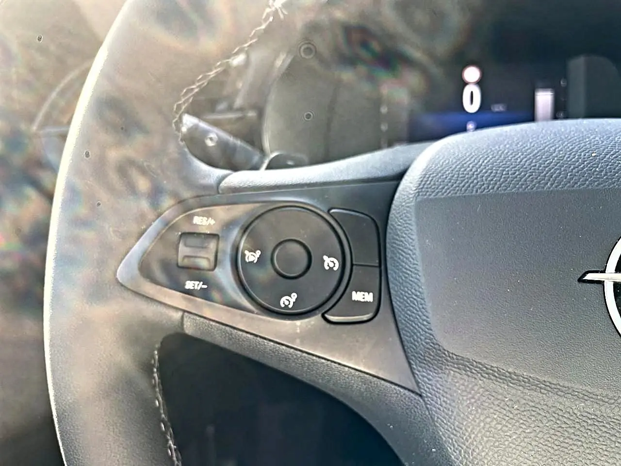 Gros plan sur la partie gauche du volant noir de l’Opel Corsa 2025 avec commandes de régulateur de vitesse.