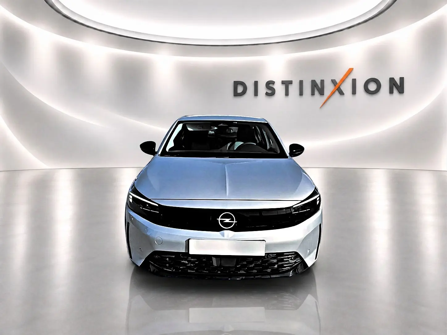 Opel Corsa gris alu vue de face dans un studio lumineux avec logo Distinxion en arrière-plan.