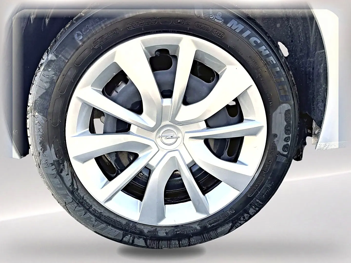 Gros plan sur la roue avant droite d'une Opel Corsa gris alu avec enjoliveur argenté et pneu Michelin.