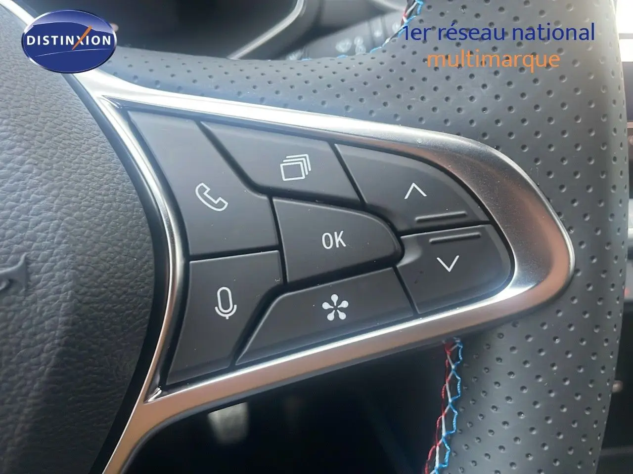 Gros plan sur les commandes multifonctions du volant perforé du Renault Captur E-Tech hybride 2025, finition Esprit Alpine.