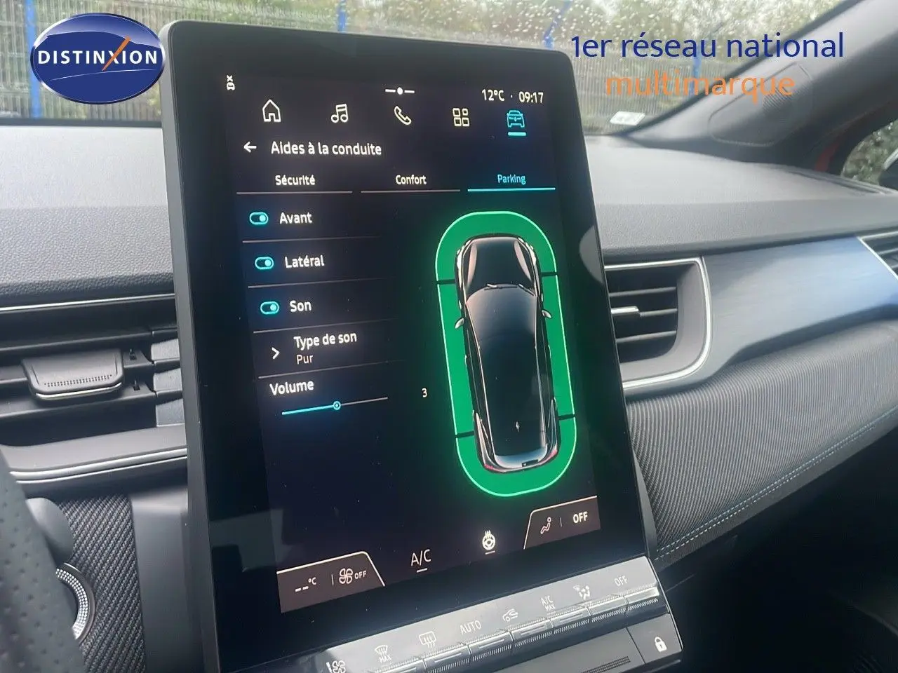 Vue intérieure centrée sur l'écran tactile du tableau de bord du Renault Captur E-Tech rouge, affichant les aides à la conduite.