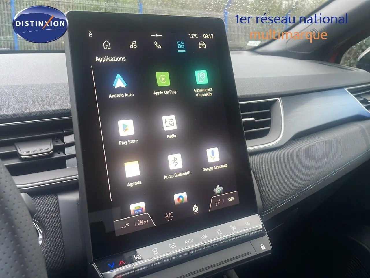 Écran tactile central vertical du tableau de bord du Renault Captur rouge passion, avec interface multimédia affichée.