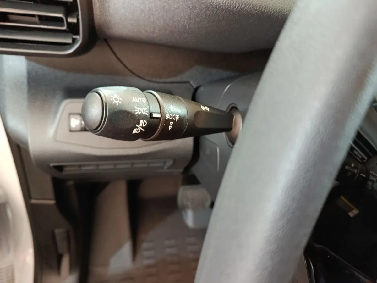 Gros plan sur la commande des phares à gauche du volant du Peugeot Partner XL blanc 2025 Diesel.