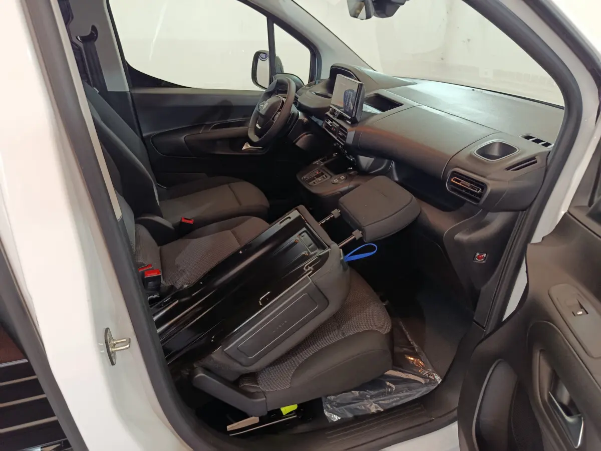 Intérieur du Peugeot Partner XL blanc 2025 vu côté conducteur, montrant sièges noirs et tableau de bord moderne.