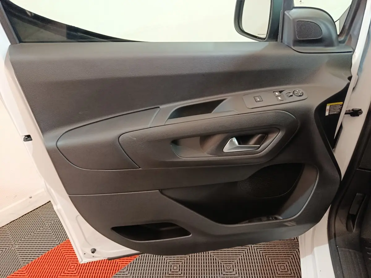 Porte côté conducteur ouverte du Peugeot Partner XL blanc 2025, montrant la garniture intérieure noire avec commandes électriques.