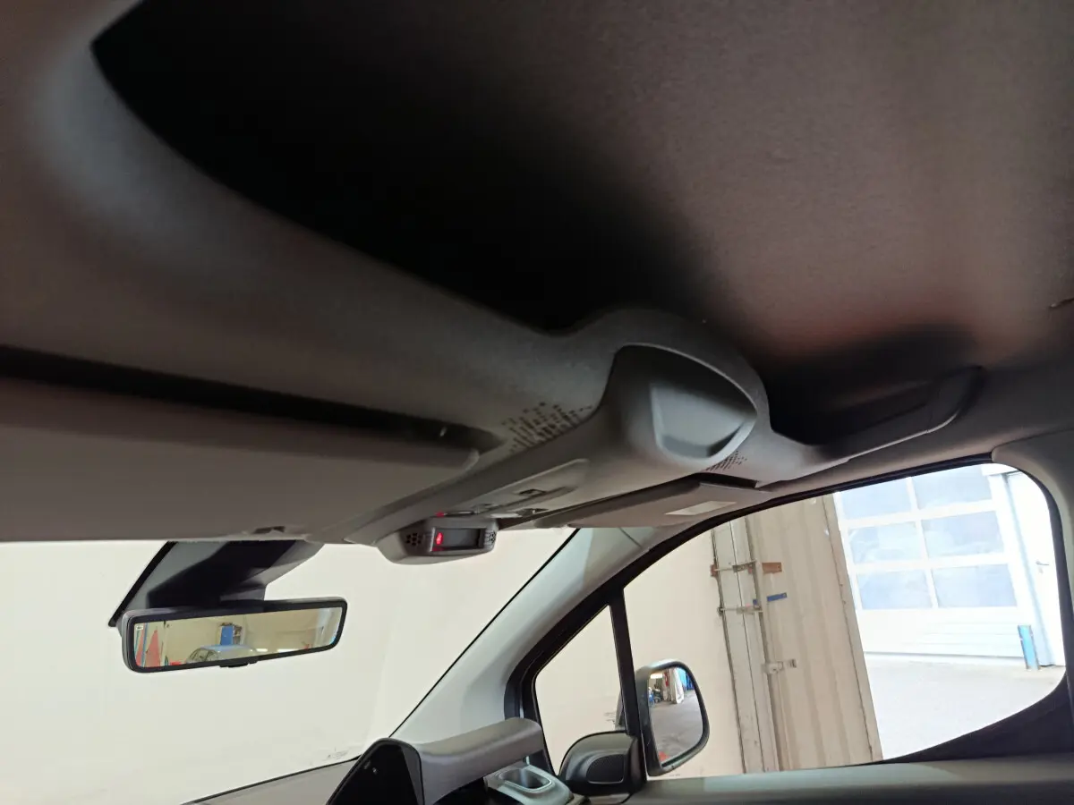 Vue intérieure côté conducteur du Peugeot Partner 2025, montrant le rétroviseur et le plafond avec capteur intégré.