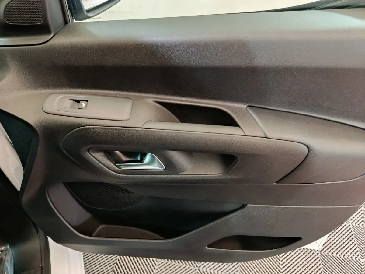 Vue rapprochée de la porte intérieure côté gauche noire du Peugeot Partner XL 2025 avec poignée argentée.