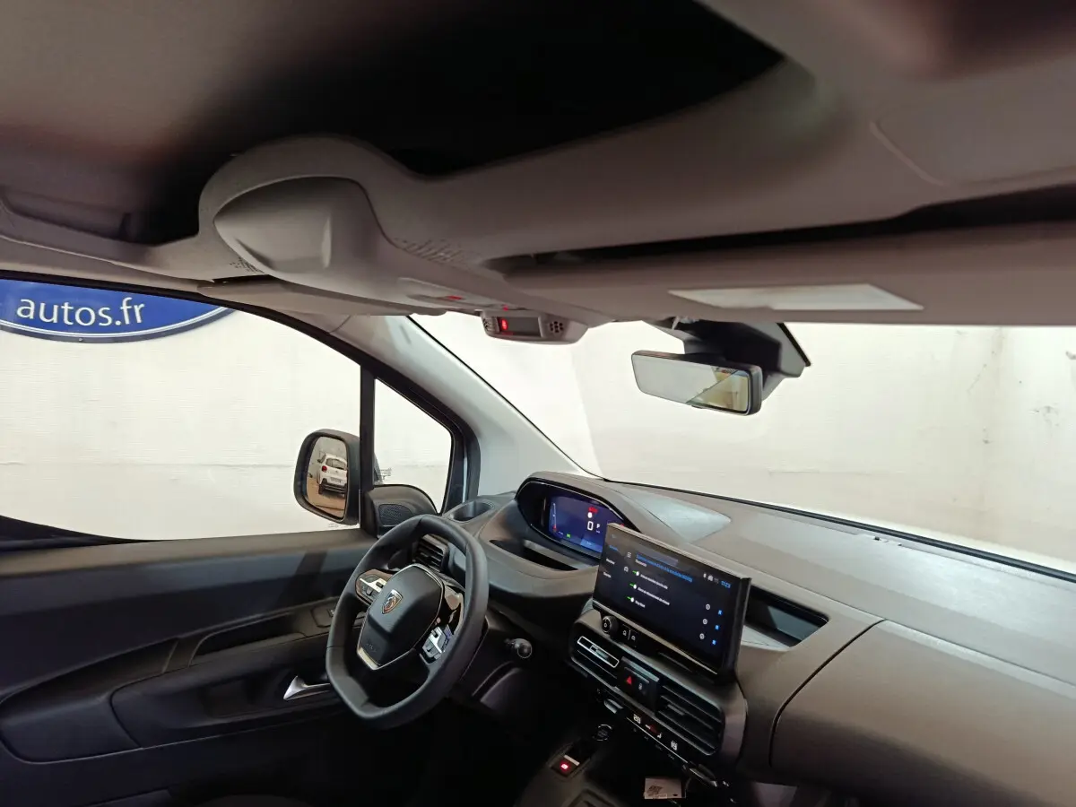 Intérieur du Peugeot Partner XL 2025 vu côté conducteur, tableau de bord moderne avec écran tactile central et volant multifonction.