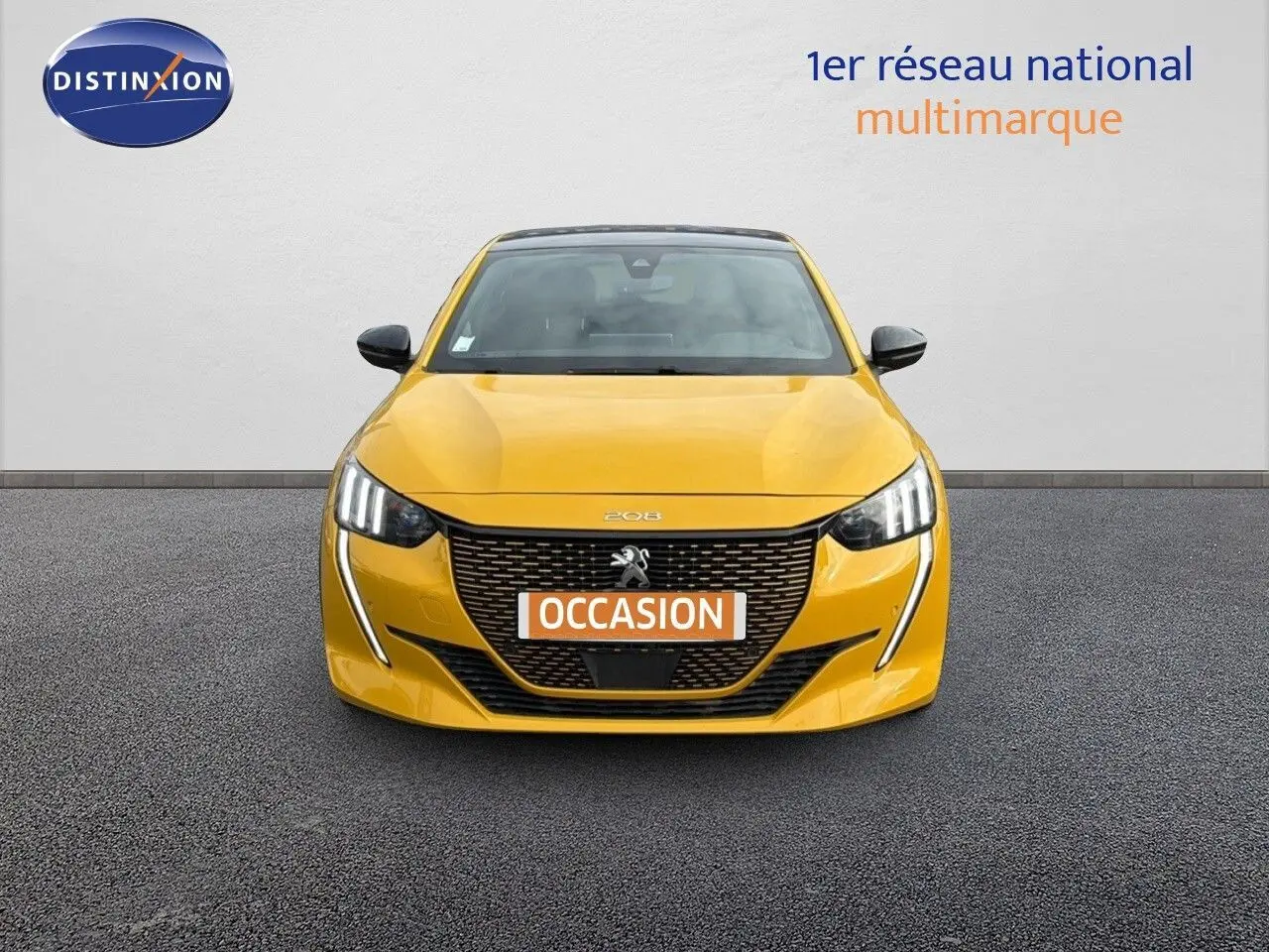 Vue frontale d'une Peugeot 208 électrique jaune Faro avec toit noir et feux LED distinctifs.