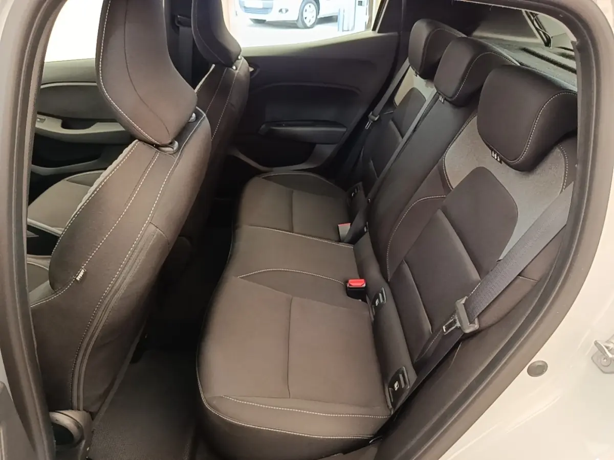 Vue intérieure côté droit sur la banquette arrière noire de la Renault Clio gris clair avec ceinture de sécurité visible.