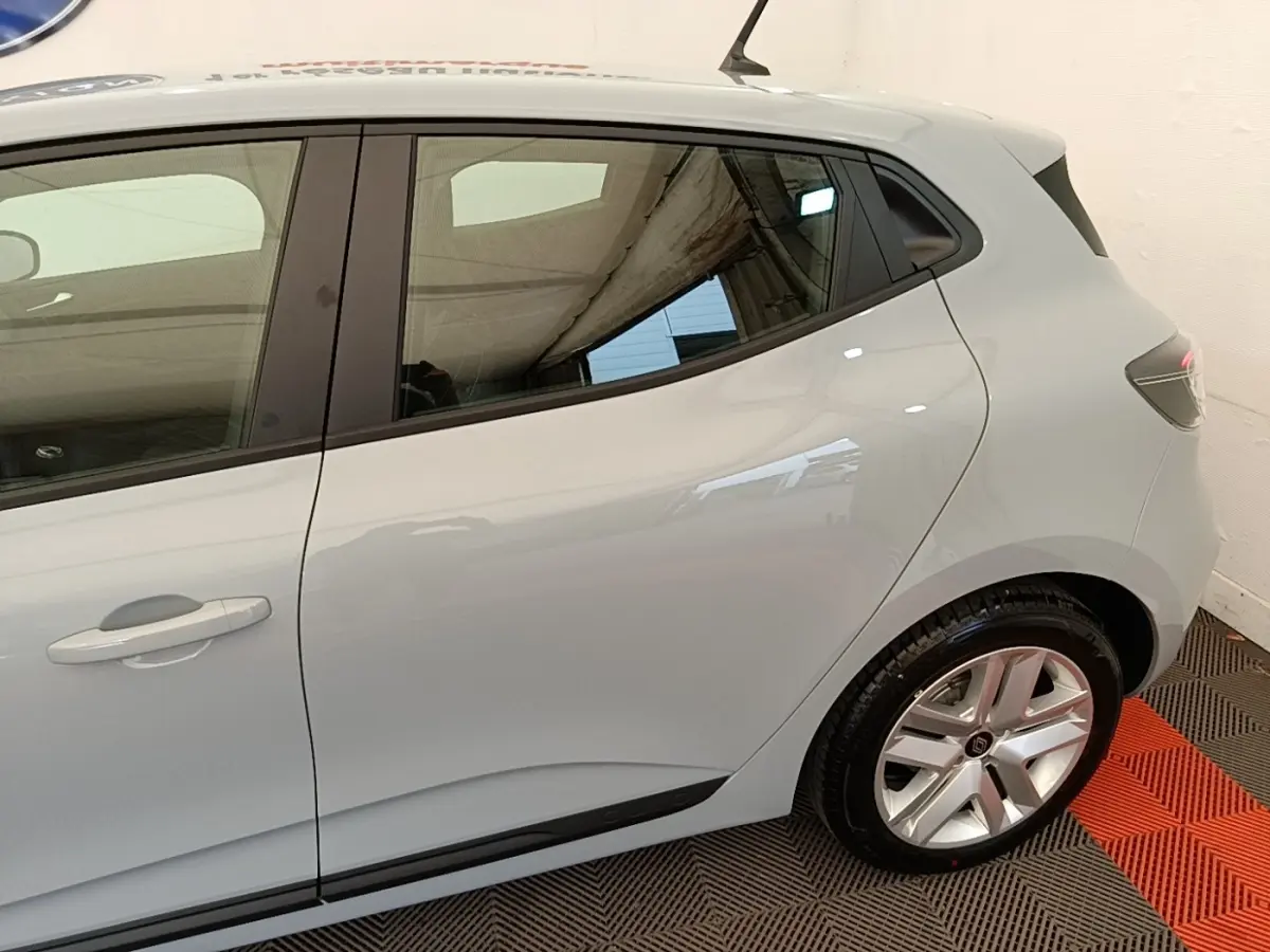 Vue latérale côté droit d'une Renault Clio gris clair 2025, mettant en valeur la ligne fluide et les jantes alliage.