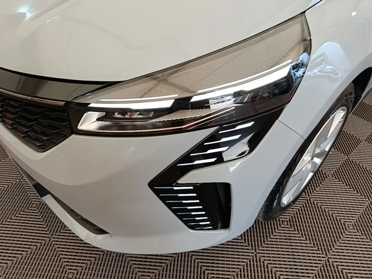 Gros plan sur l'avant droit gris clair de la Renault Clio 2025, mettant en valeur le phare LED et la calandre noire.