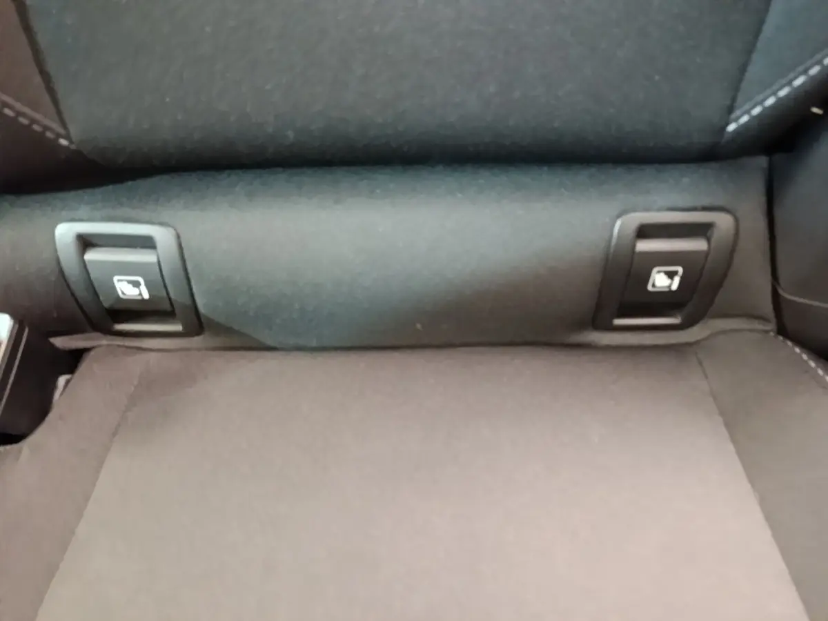 Gros plan sur la banquette arrière grise de la Renault Clio Evolution dCi 100 avec commandes de rabattement 2/3-1/3.