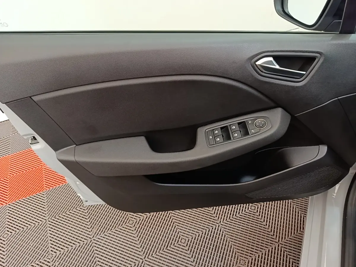 Gros plan sur la porte avant gauche de la Renault Clio gris clair, montrant les commandes des vitres et le revêtement noir.