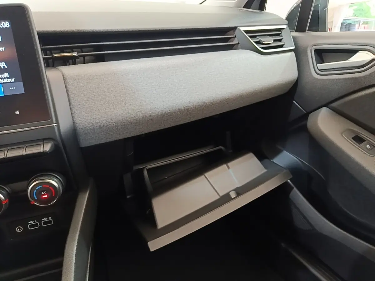 Intérieur de la Renault Clio Evolution dCi 100 2025, vue côté passager sur la boîte à gants ouverte et tableau de bord gris clair.