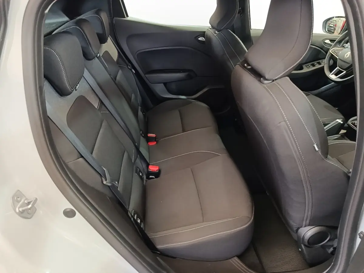 Vue intérieure côté gauche montrant la banquette arrière noire et les sièges avant d'une Renault Clio gris clair 2025.