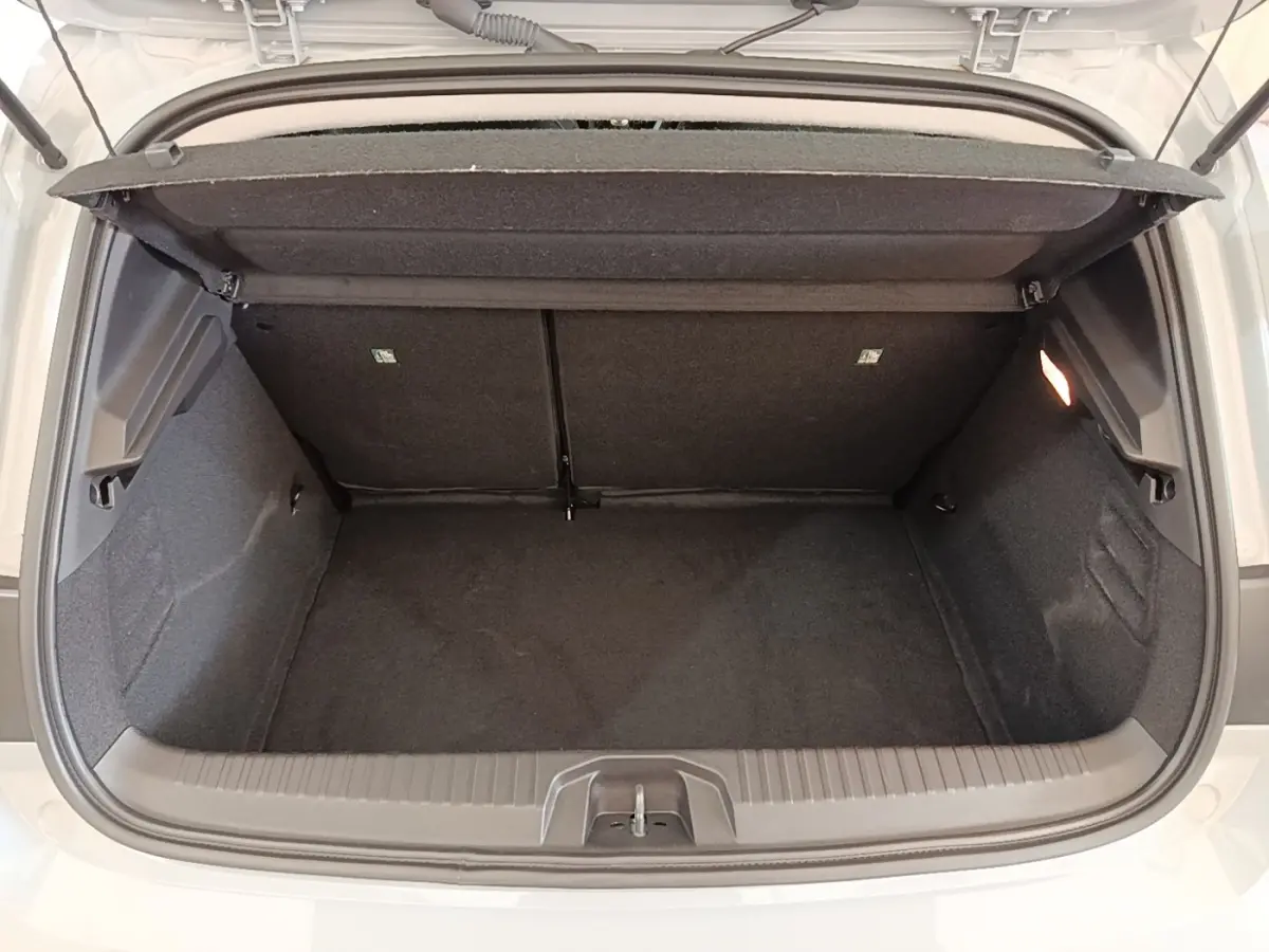Coffre ouvert vu de l'arrière d'une Renault Clio gris clair 2025, montrant l'espace de chargement vide et la tablette arrière.