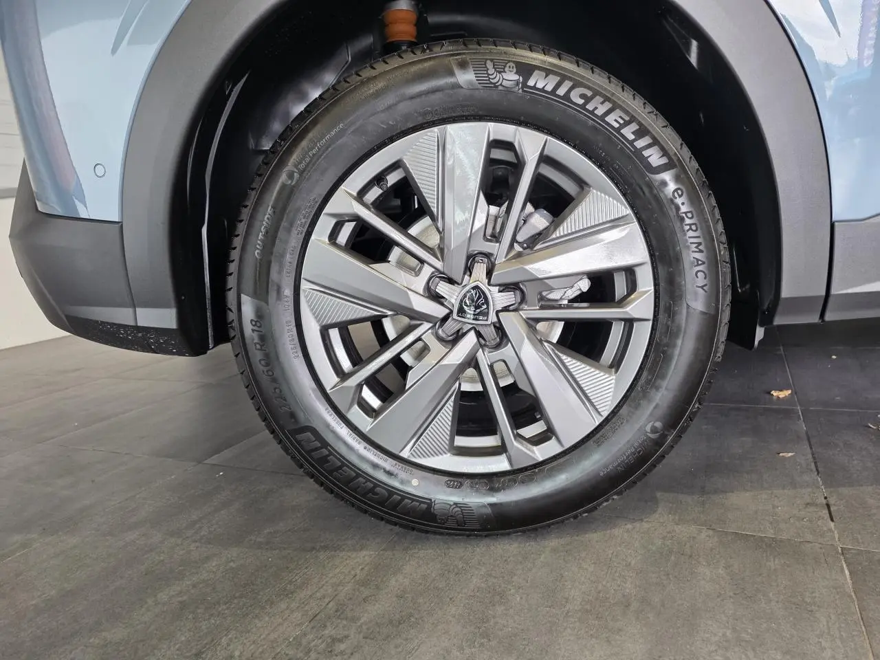 Gros plan sur la roue avant gauche du Peugeot 3008 bleu 2026 avec jante alliage 18'' Basel et pneu Michelin.