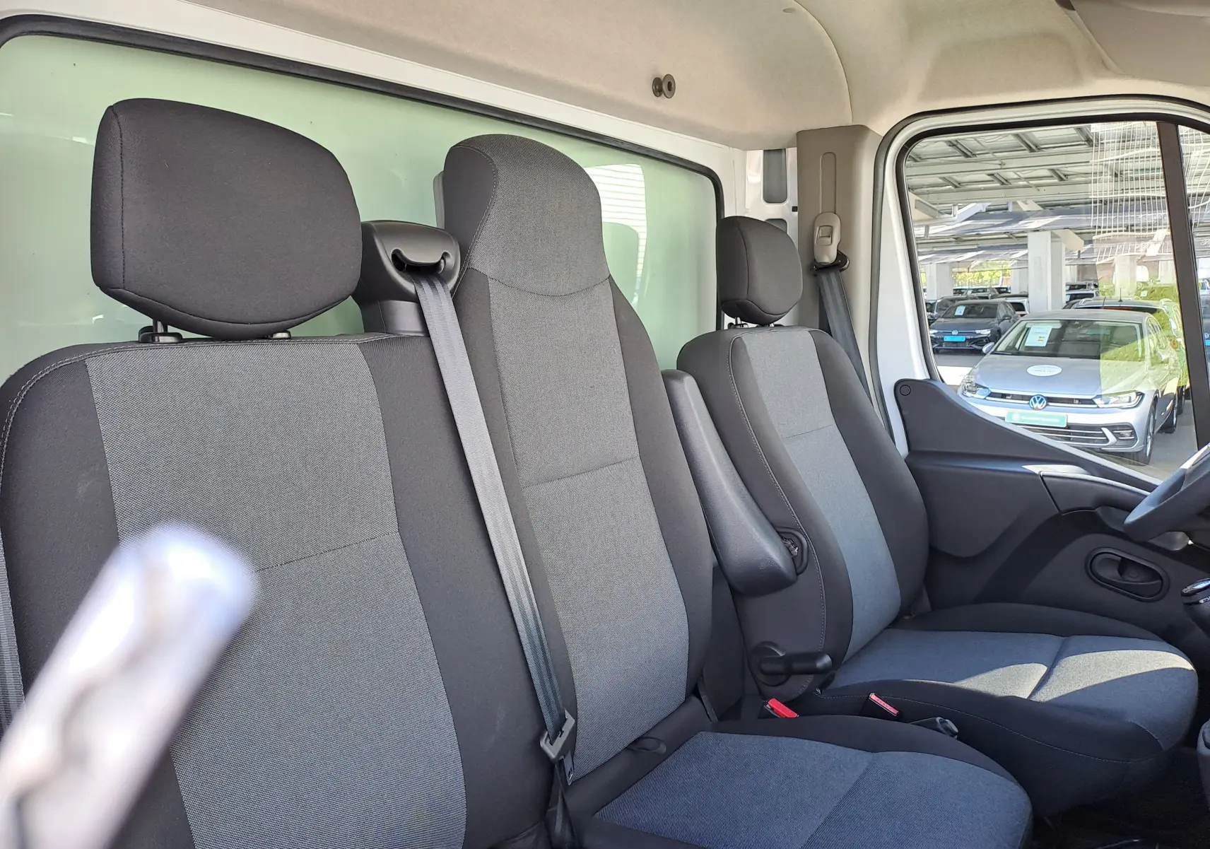 Vue intérieure côté droit du Nissan Interstar Châssis Cabine 2024, montrant les sièges tissu gris et noir avec ceinture de sécurité.