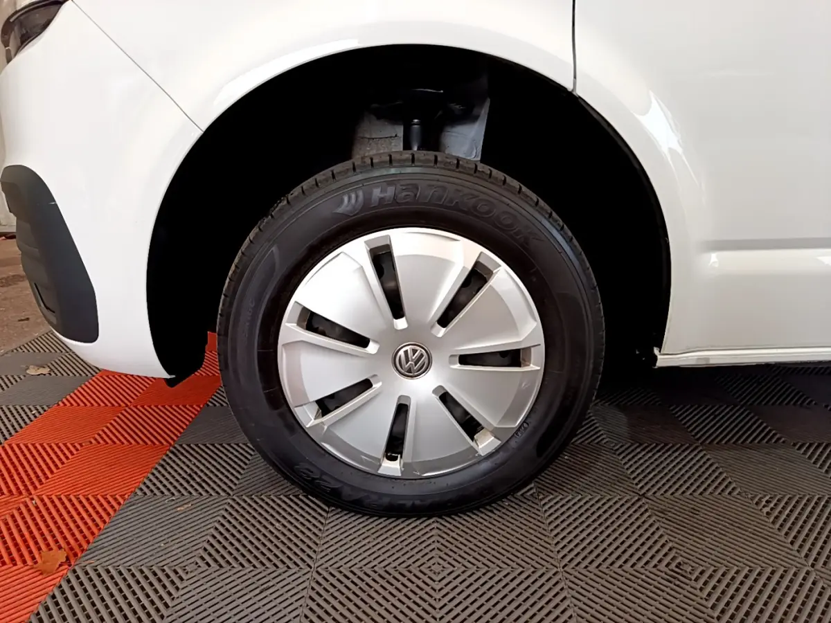 Gros plan sur la roue avant gauche blanche d'un Volkswagen Transporter 2021 avec enjoliveur argenté et pneu Hankook.