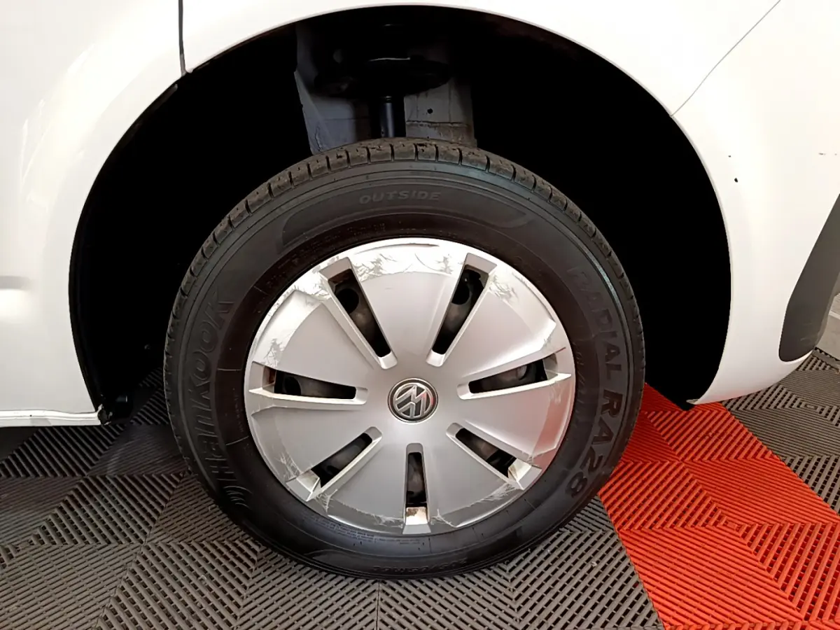 Gros plan sur la roue avant gauche blanche d'un Volkswagen Transporter 2.0 TDi 150 DSG7 avec enjoliveur abîmé.