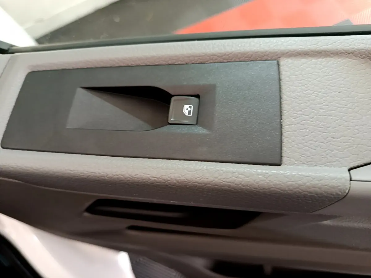 Bouton de commande de vitre électrique sur la porte intérieure grise d'un Volkswagen Transporter blanc 2021.