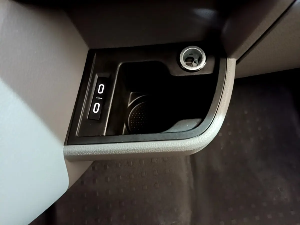 Prise 12V et double port USB intégrés dans la console inférieure côté passager du Volkswagen Transporter blanc.