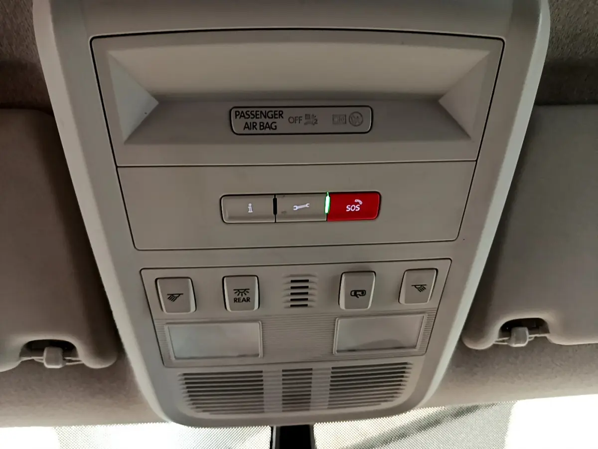 Vue en gros plan du panneau de commandes au plafond du Volkswagen Transporter blanc, avec bouton SOS rouge allumé.