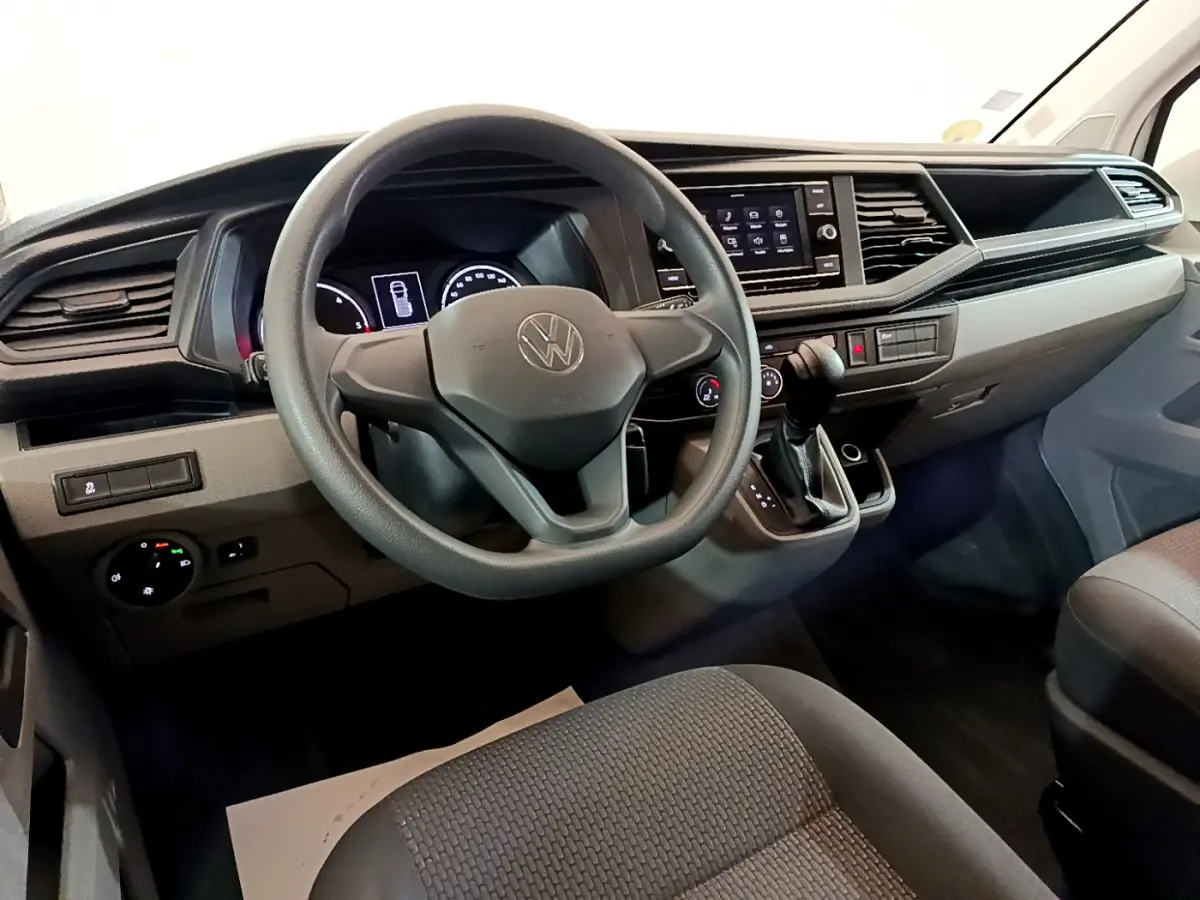 Vue intérieure du tableau de bord et volant noir du Volkswagen Transporter 2.0 TDi 150 DSG7 Business 2021.