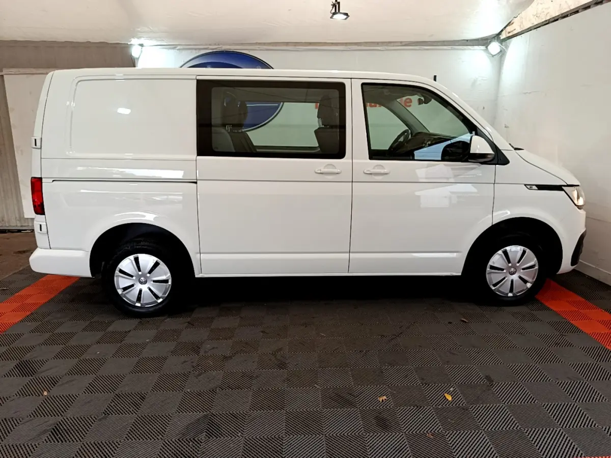 Vue latérale droite d'un Volkswagen Transporter blanc 2021 avec vitres avant et arrière côté passager.