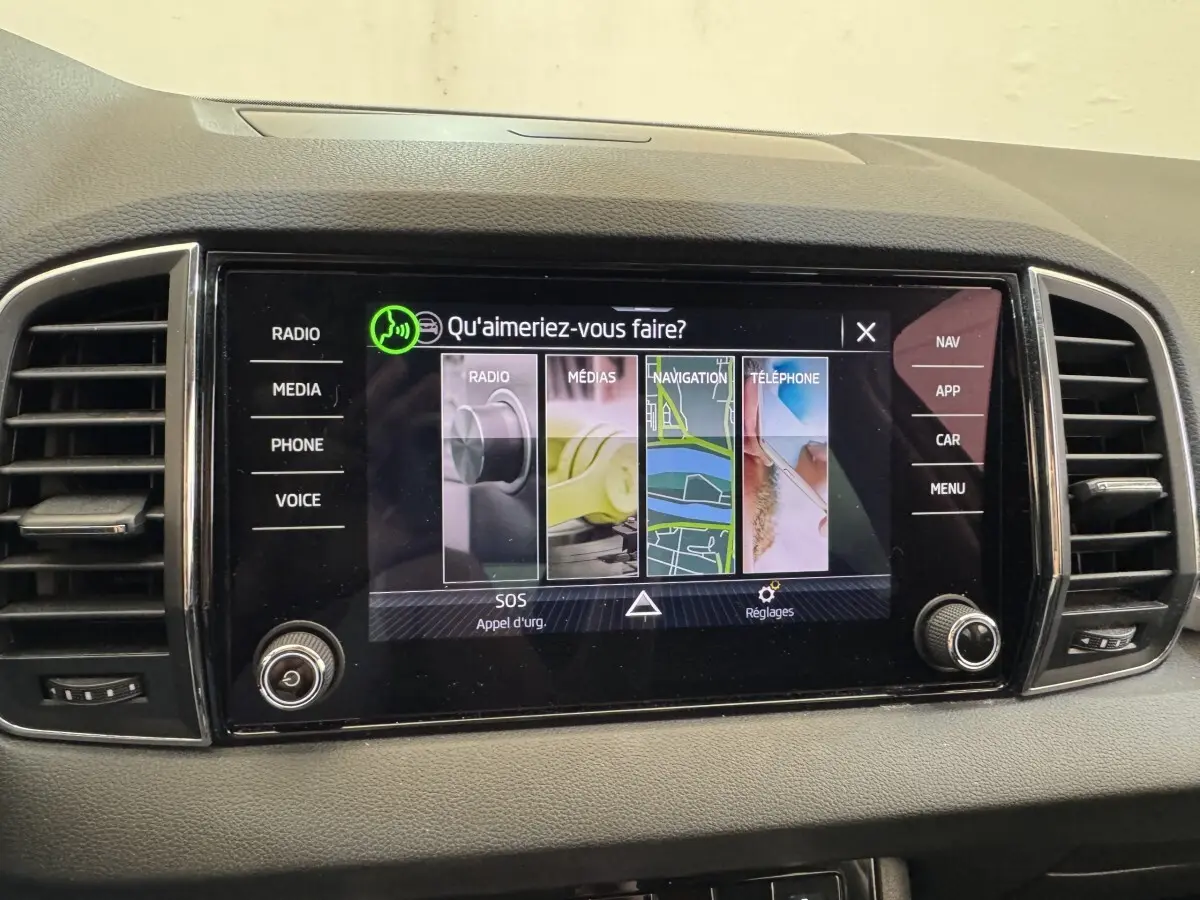 Écran tactile central du tableau de bord du Skoda Karoq blanc, affichant le menu principal multimédia et navigation.