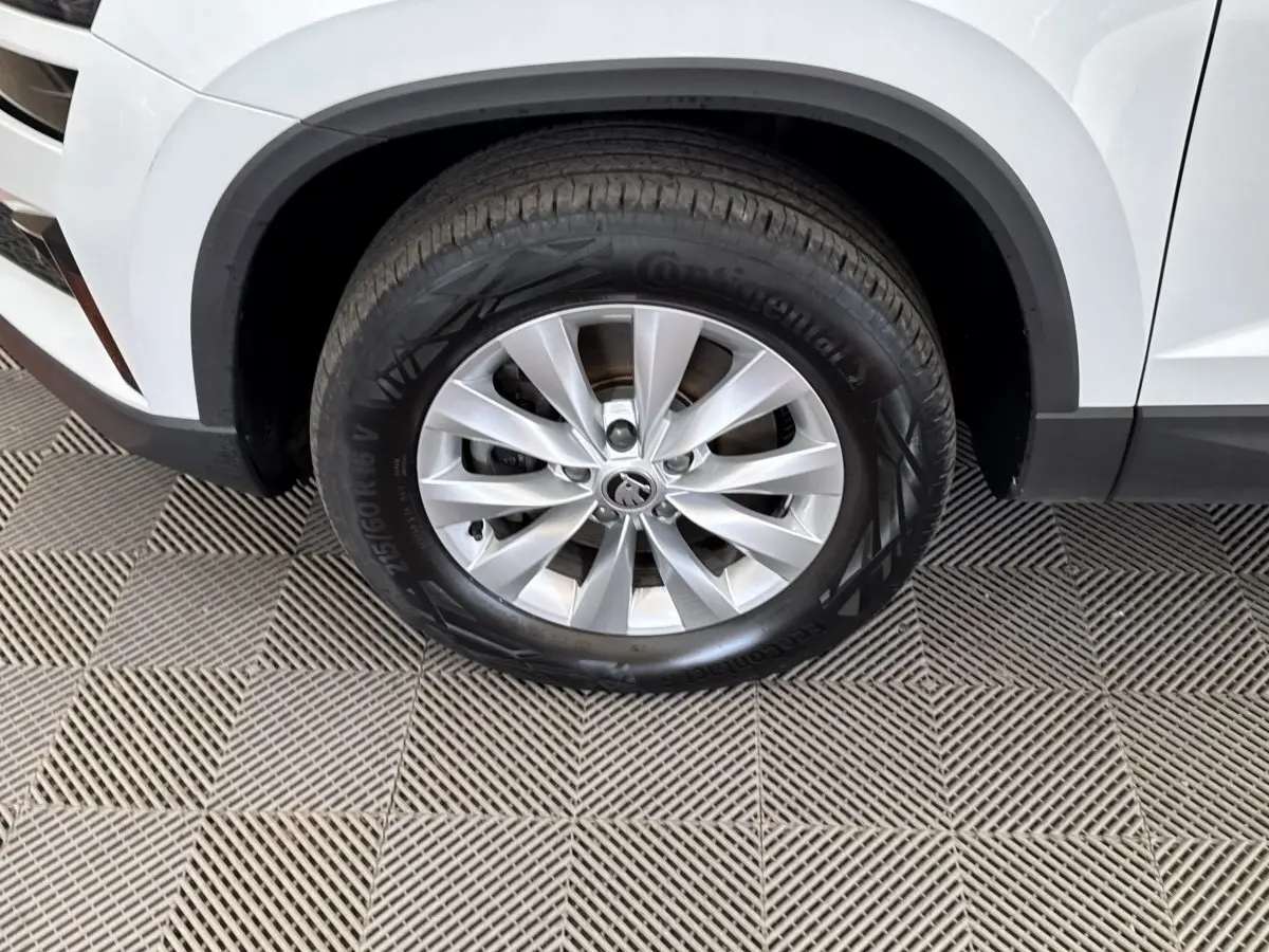 Gros plan sur la roue avant gauche blanche du Skoda Karoq 2024 avec jante alliage et pneu Continental.