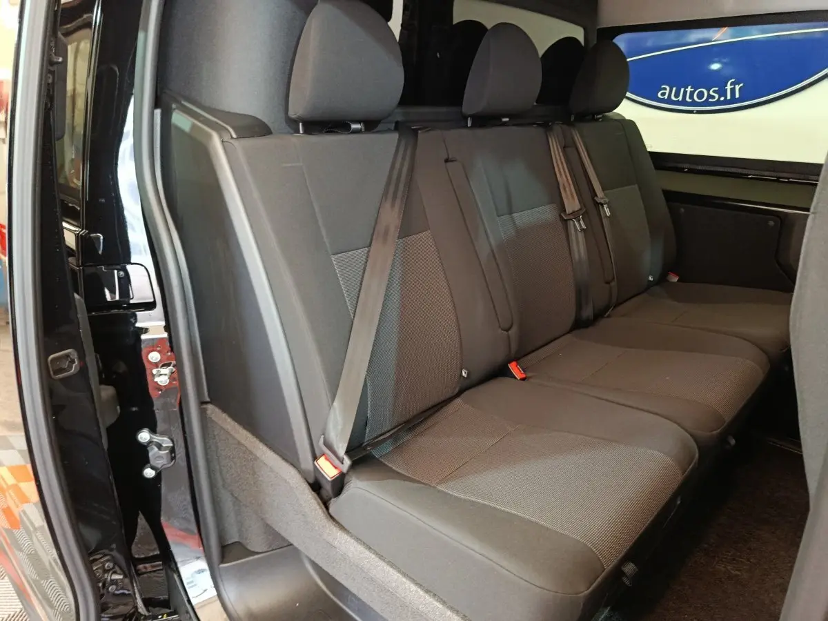 Banquette arrière noire vue côté gauche du Citroën Jumpy XL 2025 avec ceintures et appuie-têtes visibles.
