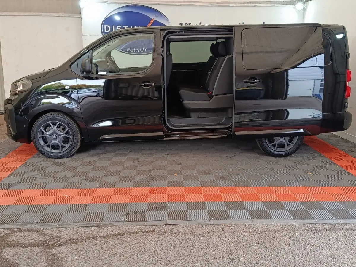 Vue latérale gauche d'un Citroën Jumpy XL noir avec porte coulissante ouverte dévoilant la banquette arrière.
