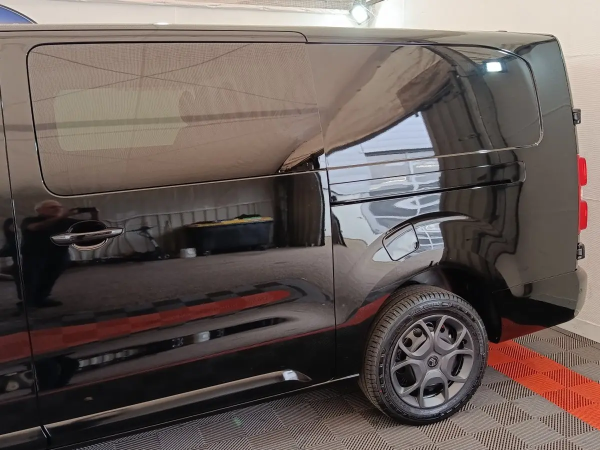 Vue latérale droite du Citroën Jumpy XL noir avec vitre teintée et jante alliage distinctive.