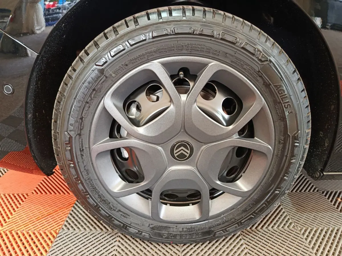 Gros plan sur la roue arrière gauche noire du Citroën Jumpy XL 2025, montrant le pneu et l'aile du véhicule.