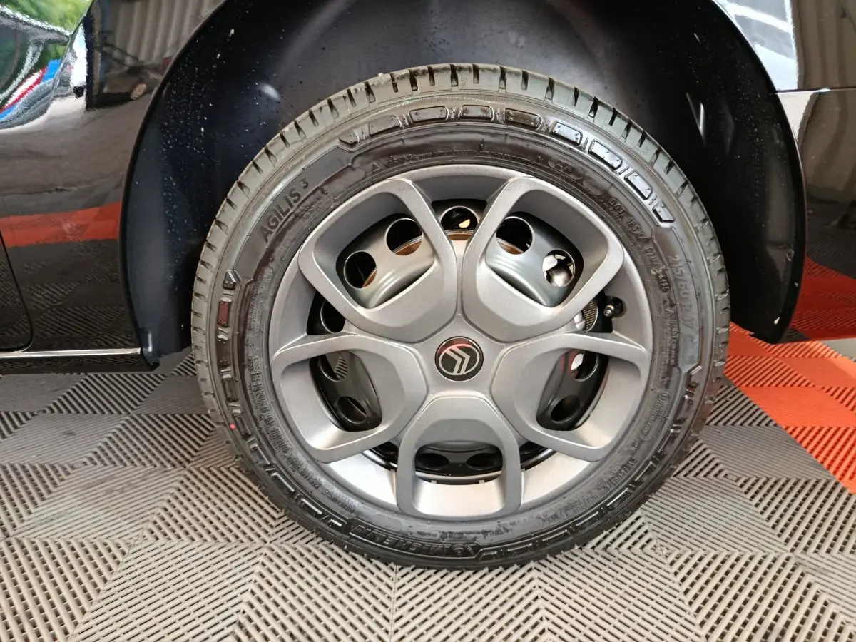 Gros plan sur la roue avant gauche du Citroën Jumpy XL noir, mettant en valeur la jante alu et le logo central.