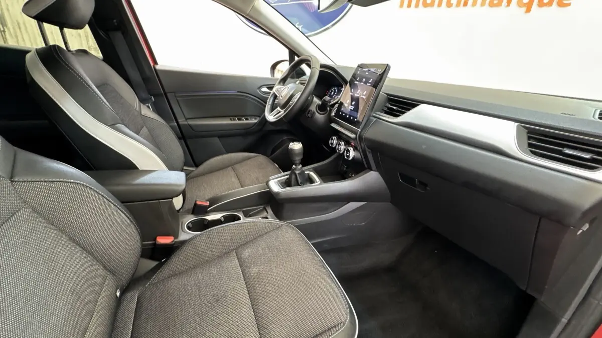 Vue intérieure côté conducteur du Renault Captur techno TCe 90 2024, sièges tissu gris et écran tactile vertical.