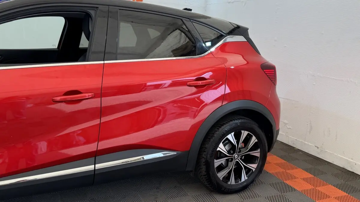 Vue latérale droite du Renault Captur rouge 2024, soulignant la ligne de caisse chromée et les jantes alliage noires.